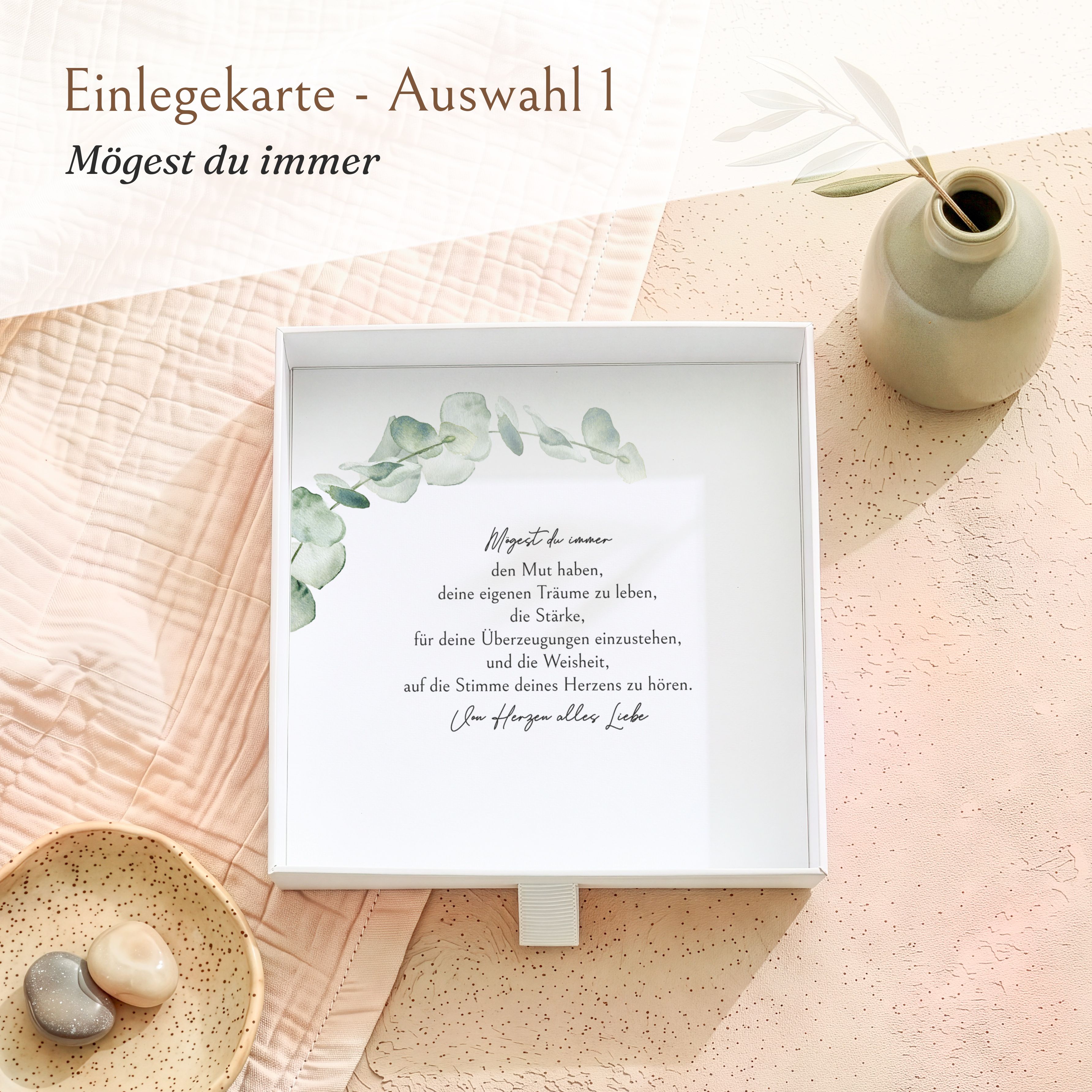 Weiße Geschenkbox aus Karton, geöffnet, mit bedruckter Einlegekarte. Die Karte zeigt Eukalyptus-Motive und den Spruch 'Mögest du immer...' zur Firmung.