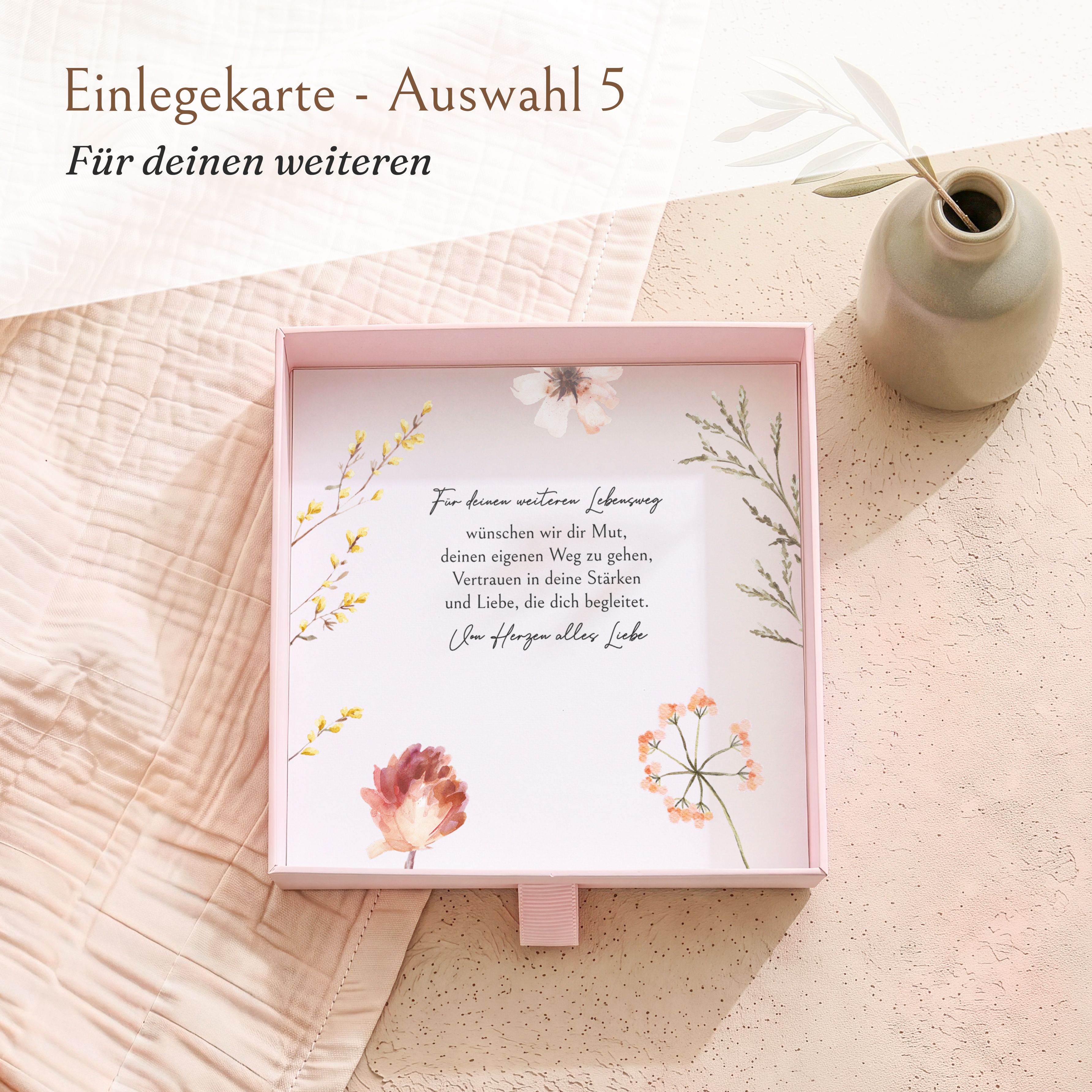 Eine offene rosa Schiebeschachtel aus Karton für Geldgeschenke zur Firmung. Innen liegt eine bedruckte Einlegekarte mit einem Blumenwiesen-Motiv und inspirierendem Text.