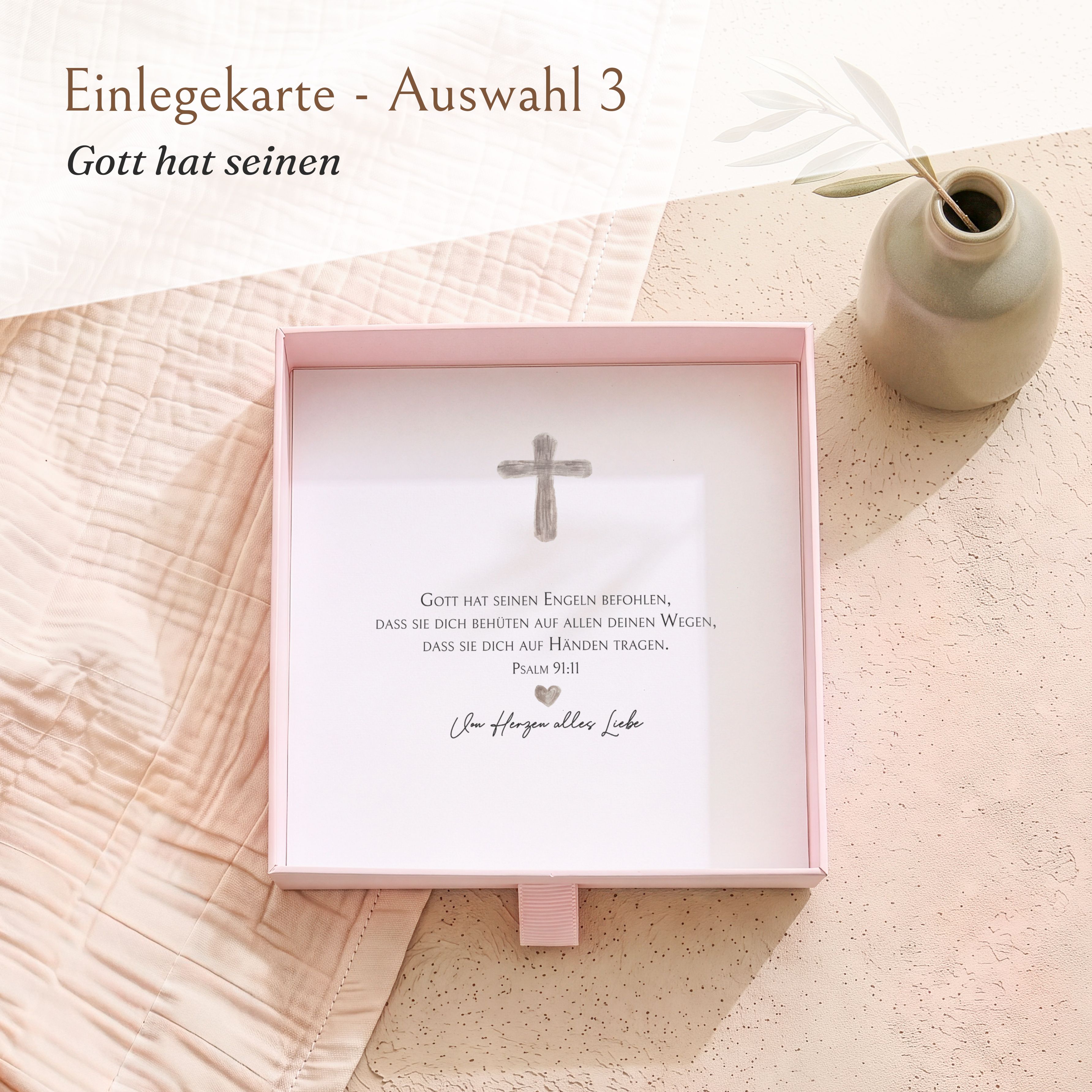 Geschenkbox aus Karton in Rosa, mit geöffnetem Deckel. Darin eine bedruckte Einlegekarte zur Firmung mit Kreuz-Motiv und dem Bibelvers Psalm 91:11.