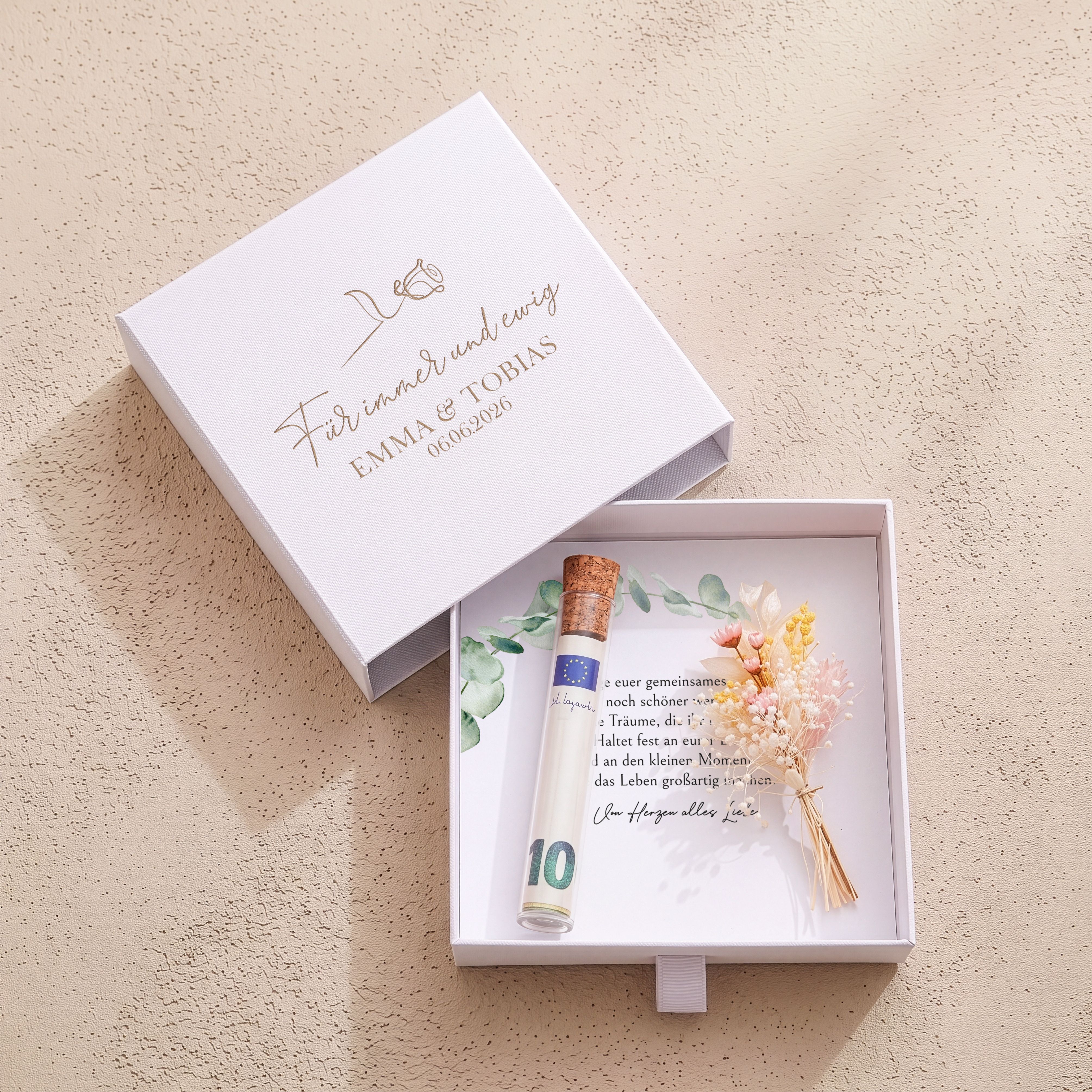 Weiße Hochzeits-Kartonbox. Goldene Deckelgravur 'Für immer und ewig' & Rosenmotiv. Innen: Karte, Röhrchen, Trockenblumen.