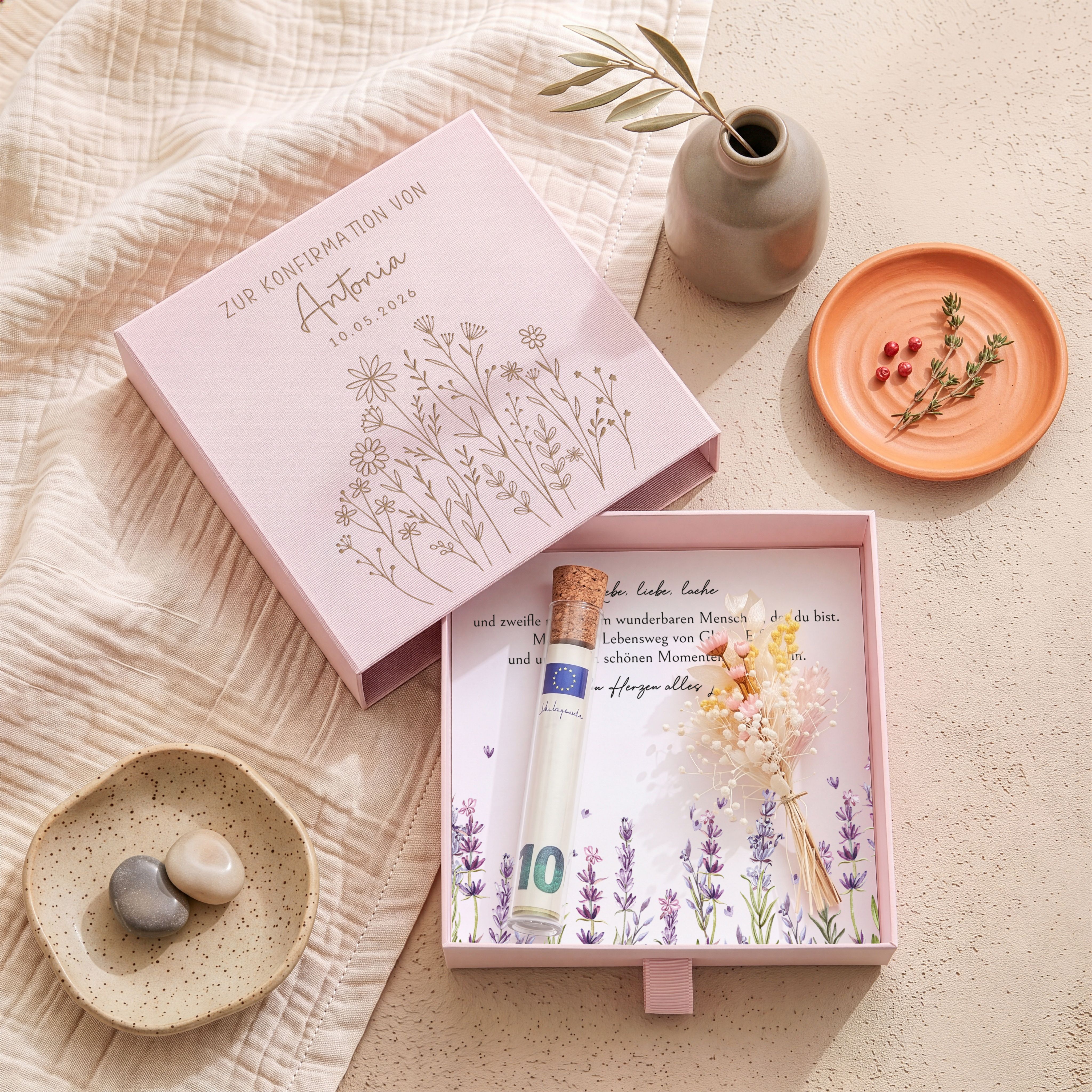 Rosa Karton-Geschenkbox zur Konfirmation mit Blumenwiesen-Gravur. Innen: Einlegekarte, Kunststoffröhrchen und Trockenblumensträußchen.