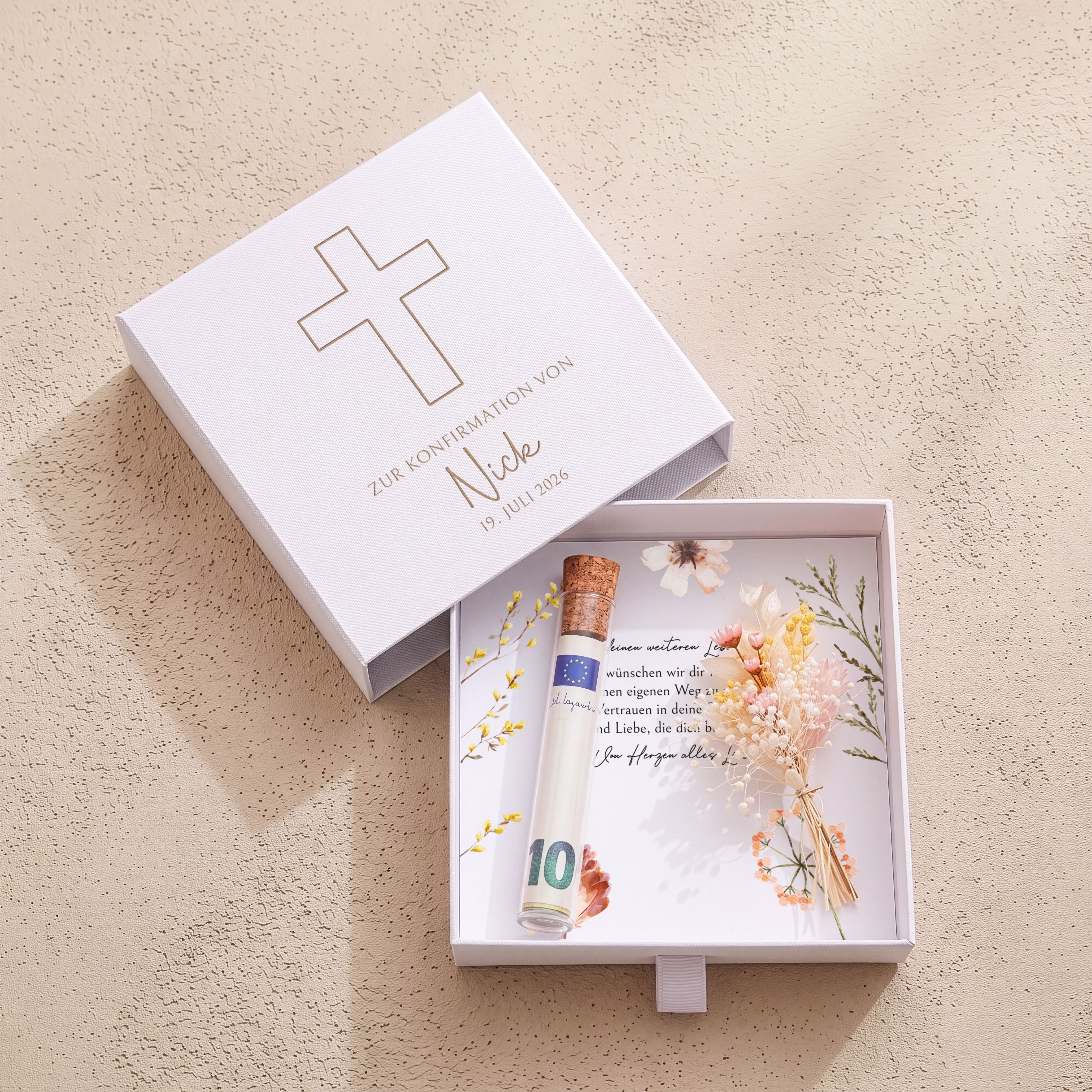 Weiße Kartonschachtel Konfirmation mit goldener Kreuz-Gravur. Enthält bedruckte Einlegekarte, Röhrchen und beige Trockenblumen.