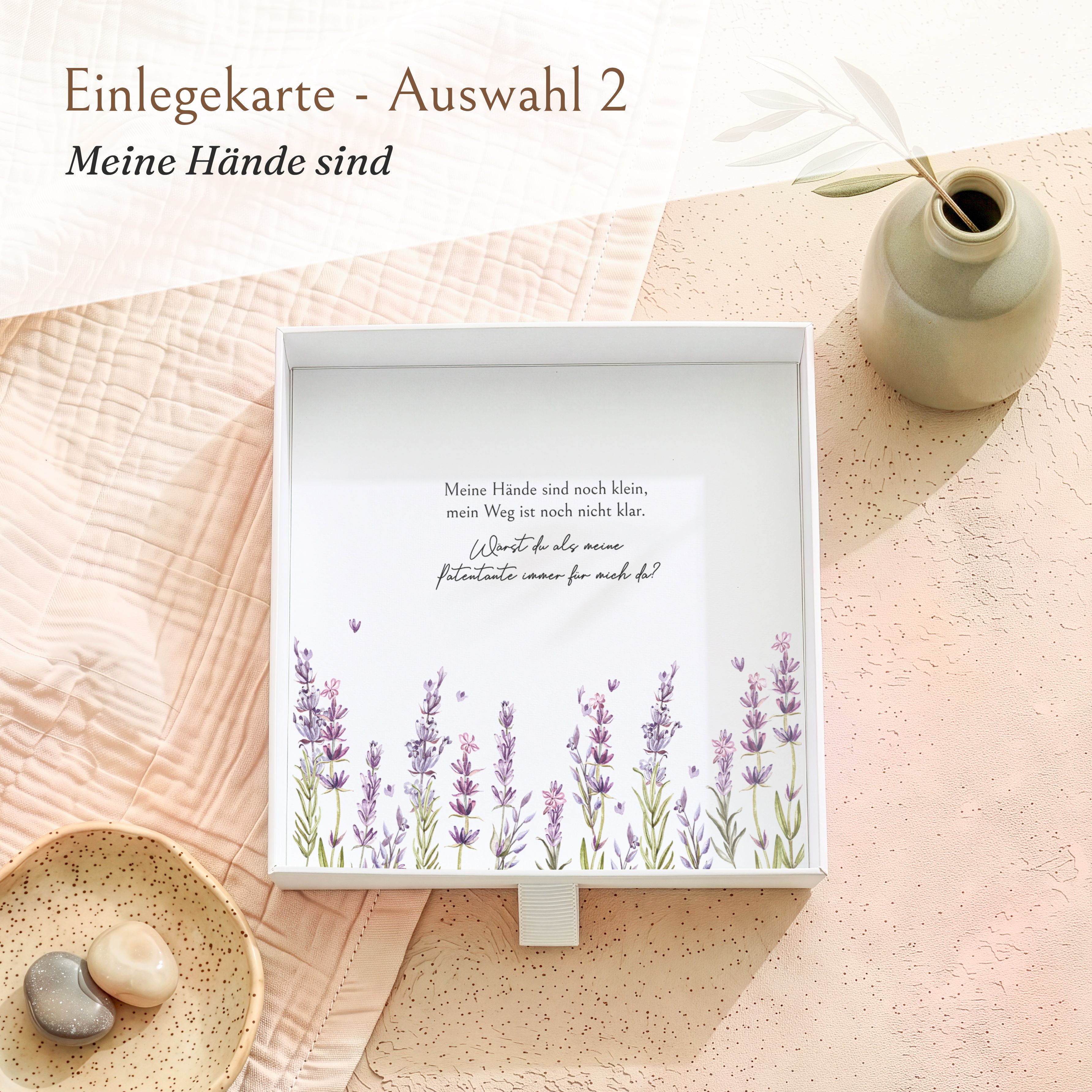 Offene weiße Geschenkbox aus Karton mit Einlegekarte. Diese zeigt eine Patenfrage im Lavendel-Design, beginnend mit 'Meine Hände sind'.
