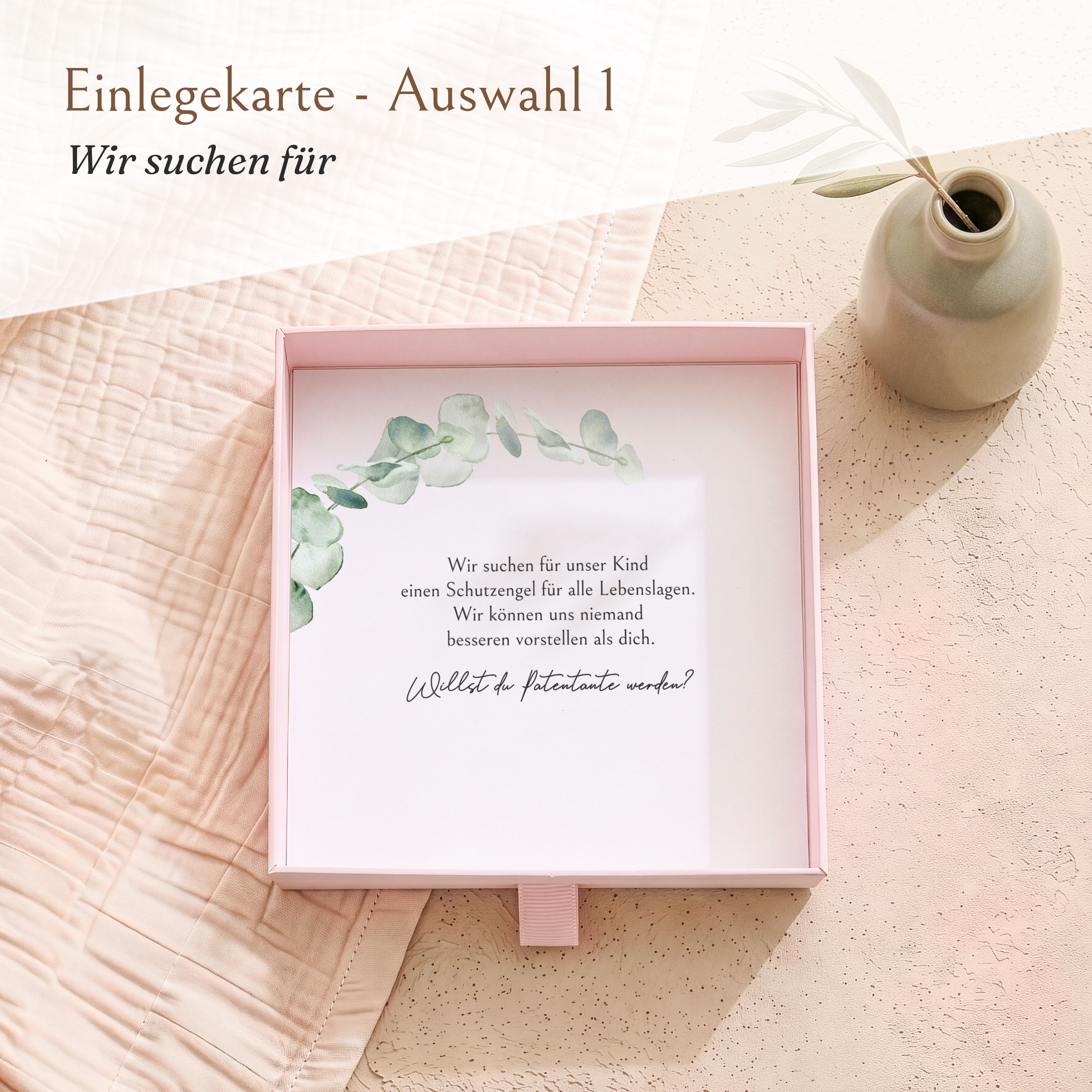 Offene rosa Geschenkbox aus Karton mit einer Einlegekarte für die Patenfrage. Die Karte zeigt ein Eukalyptus-Design und den Text 'Willst du Patentante werden?'.