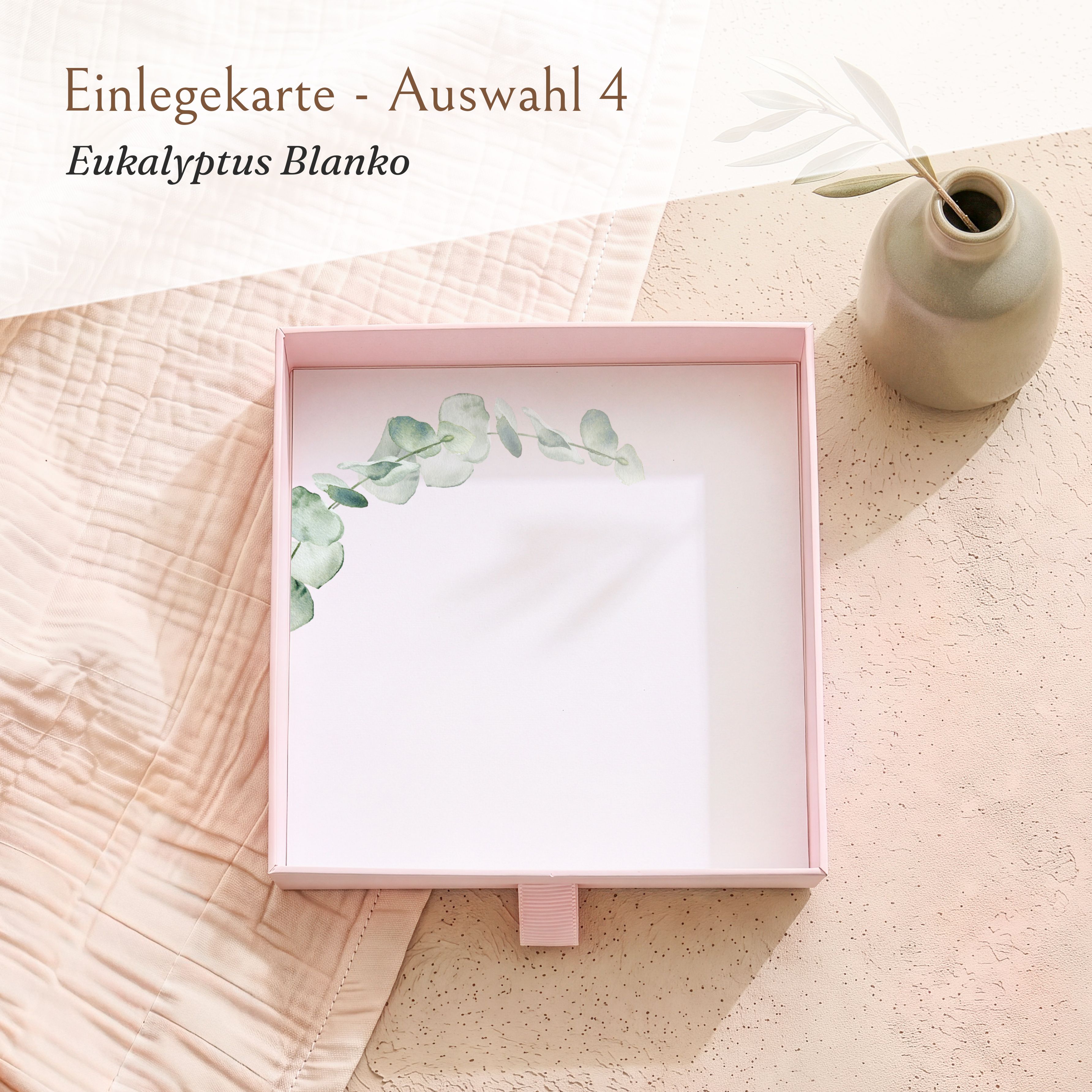 Rosa Schiebeschachtel aus strukturiertem Karton, geöffnet. Im Inneren liegt eine bedruckte Einlegekarte mit zartem Eukalyptus-Design. Rosa Bandzug.
