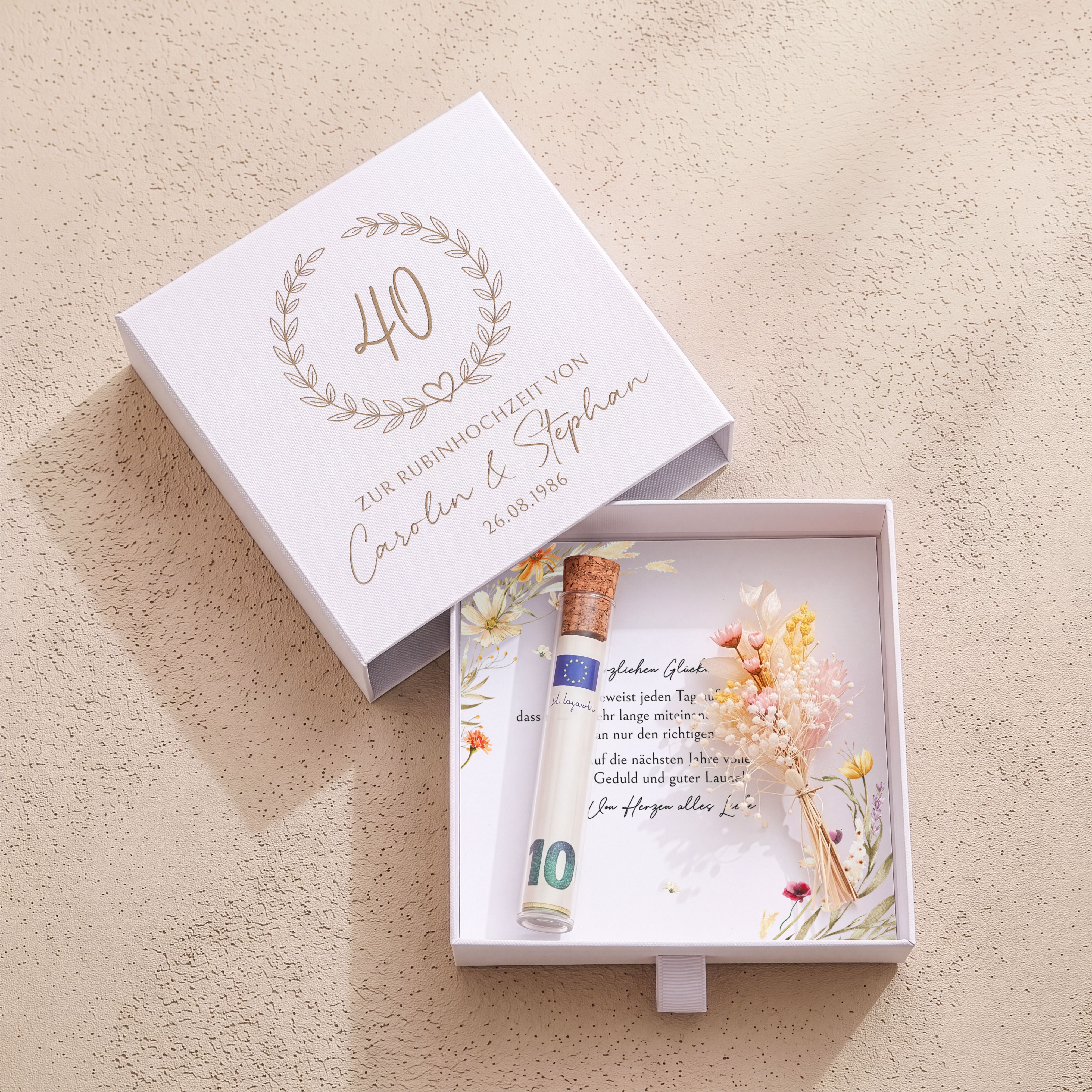 Weiße Karton-Geschenkbox zur Rubinhochzeit. Deckel mit Blätterkranz, Zahl 40. Innen florale Einlegekarte, Kunststoffröhrchen, Trockenblumen.