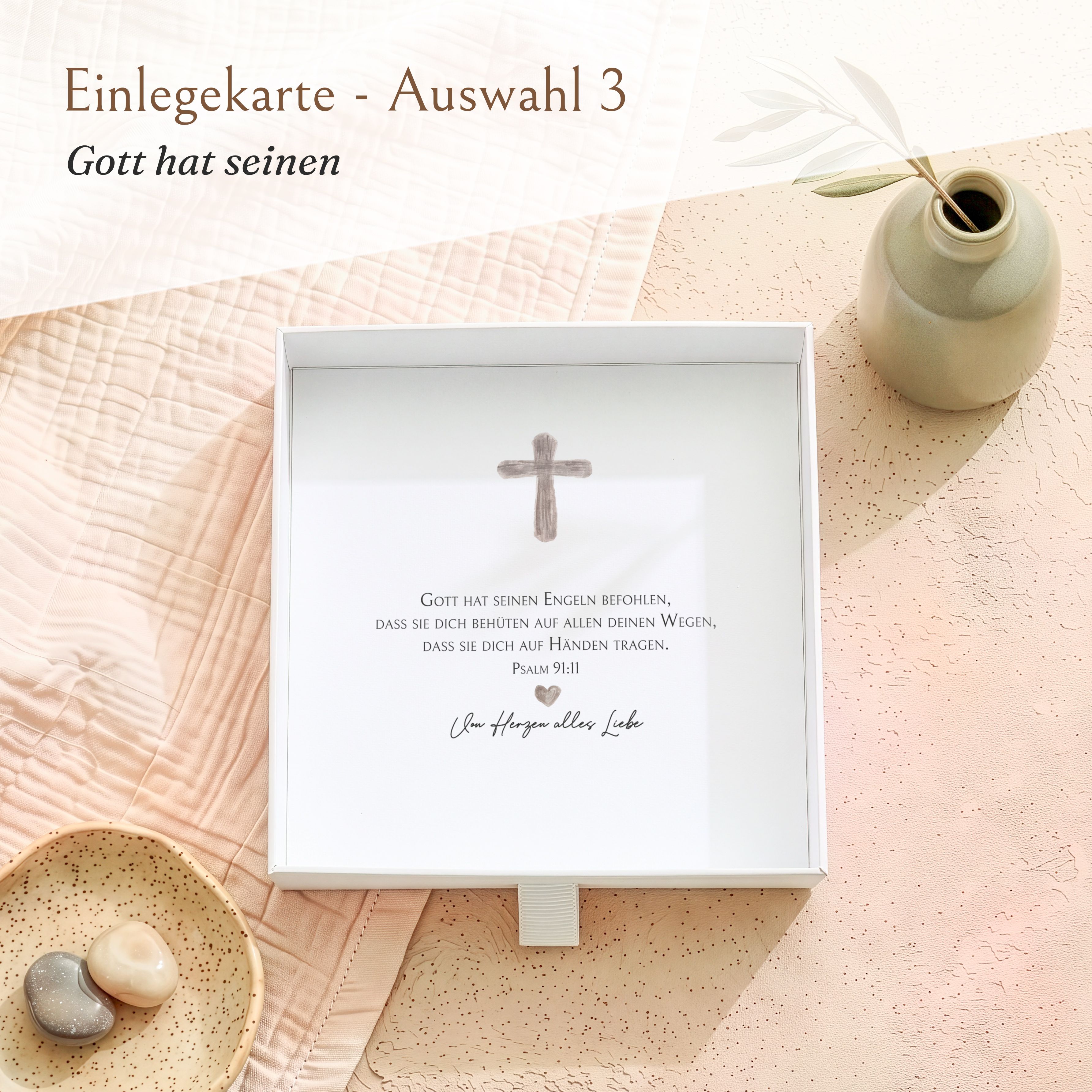 Weiße Geschenkbox aus Karton zur Konfirmation, offen mit bedruckter Einlegekarte. Die Karte zeigt ein graues Kreuzmotiv und einen Bibelvers.