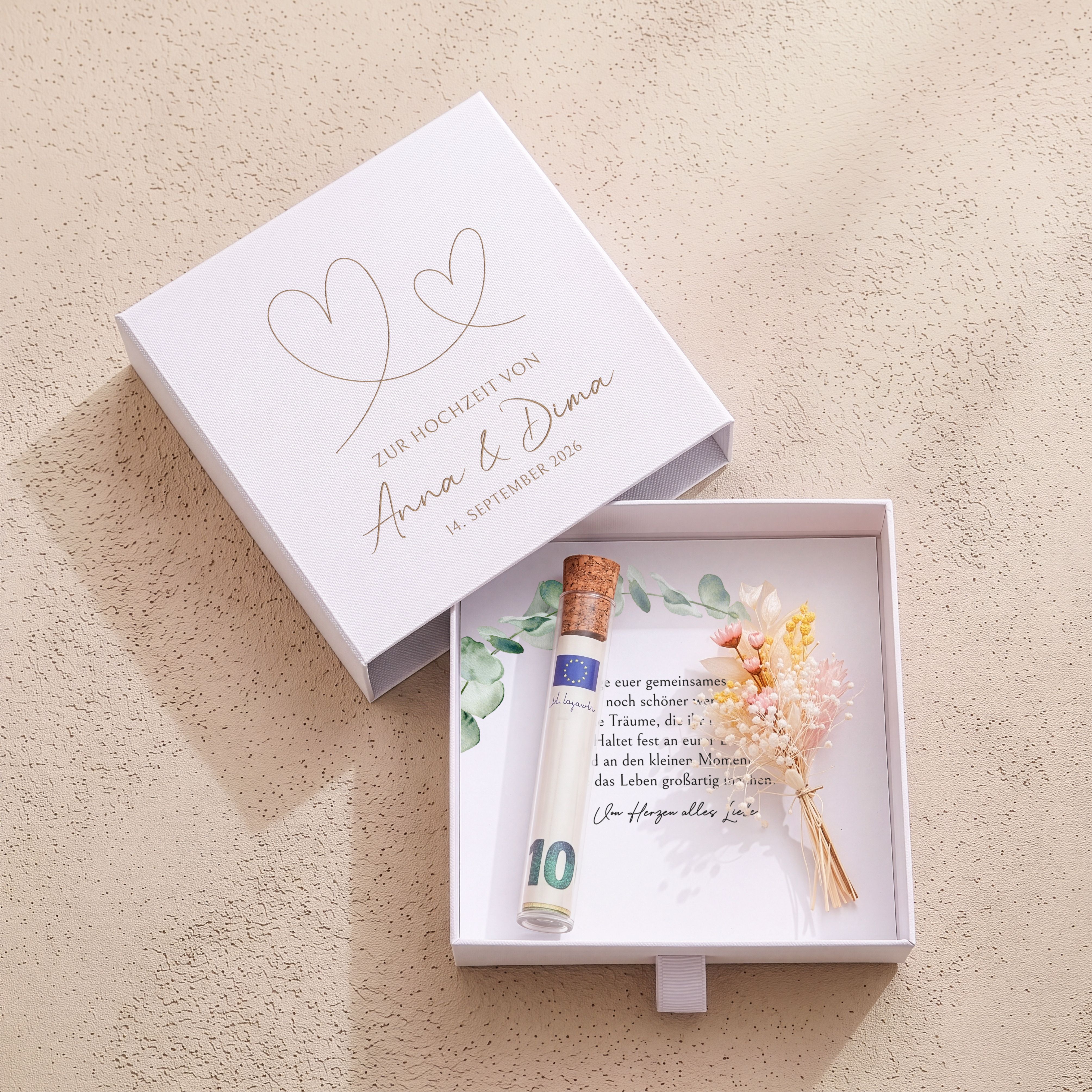Weiße Geschenkbox Karton Hochzeit. Gravur: Herzen, Namen, Datum. Innen: Einlegekarte, Röhrchen, Trockenblumen.