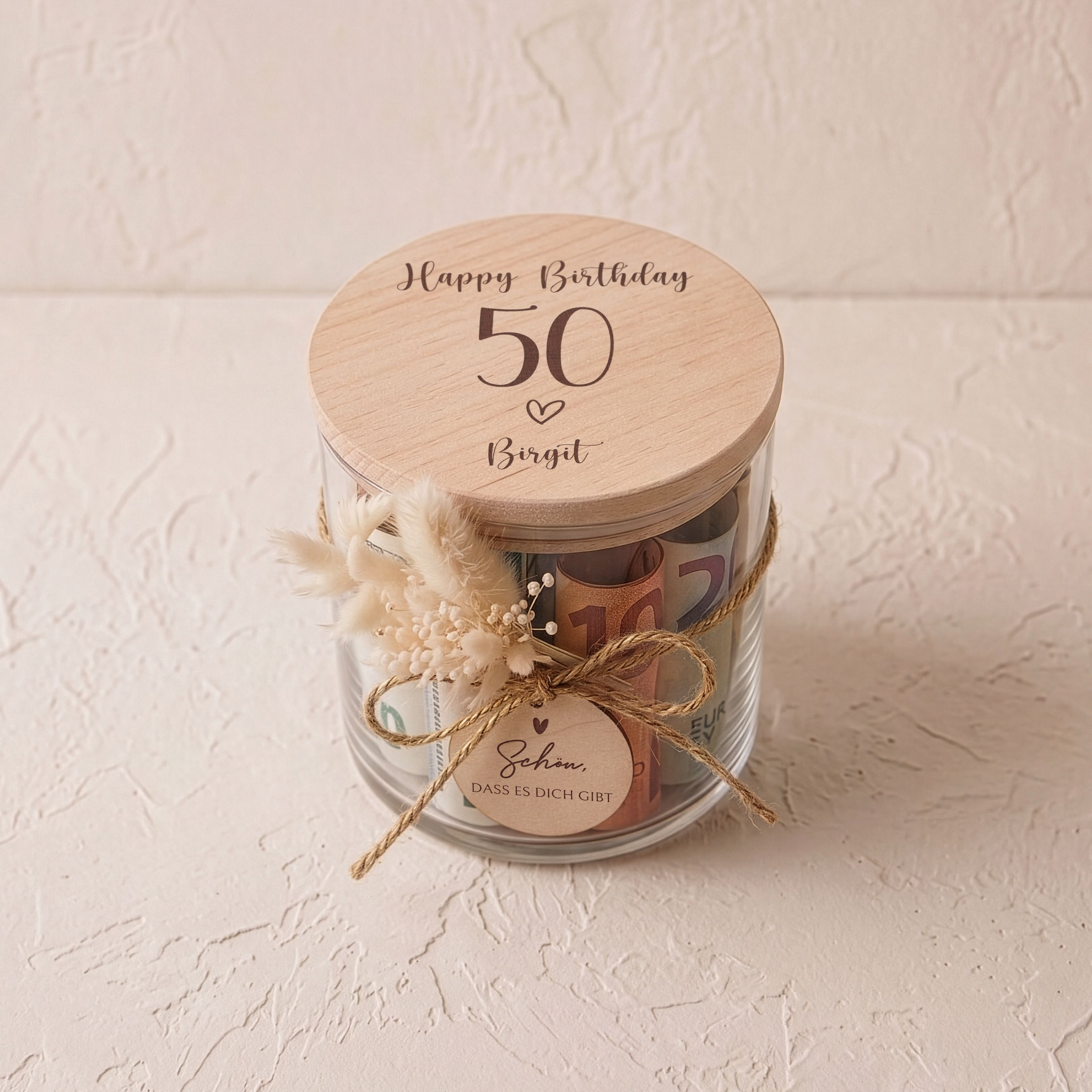 Personalisiertes Vorratsglas mit graviertem Buchenholzdeckel 'Happy Birthday'. Dekoriert mit einem runden Holzanhänger und beigefarbenen Trockenblumen.