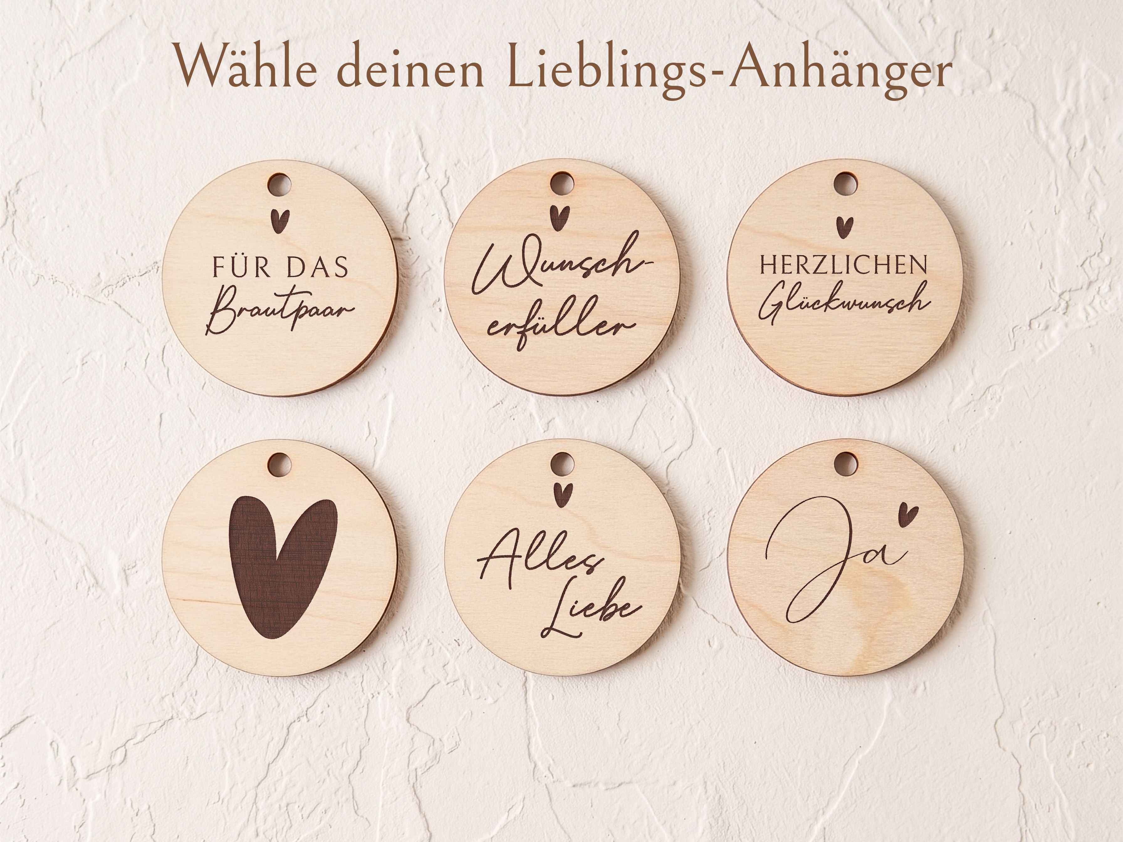 Sechs runde Holzanhänger in Naturholzoptik mit verschiedenen Gravurmotiven zur Hochzeit, darunter „Für das Brautpaar“ und ein Herzsymbol.