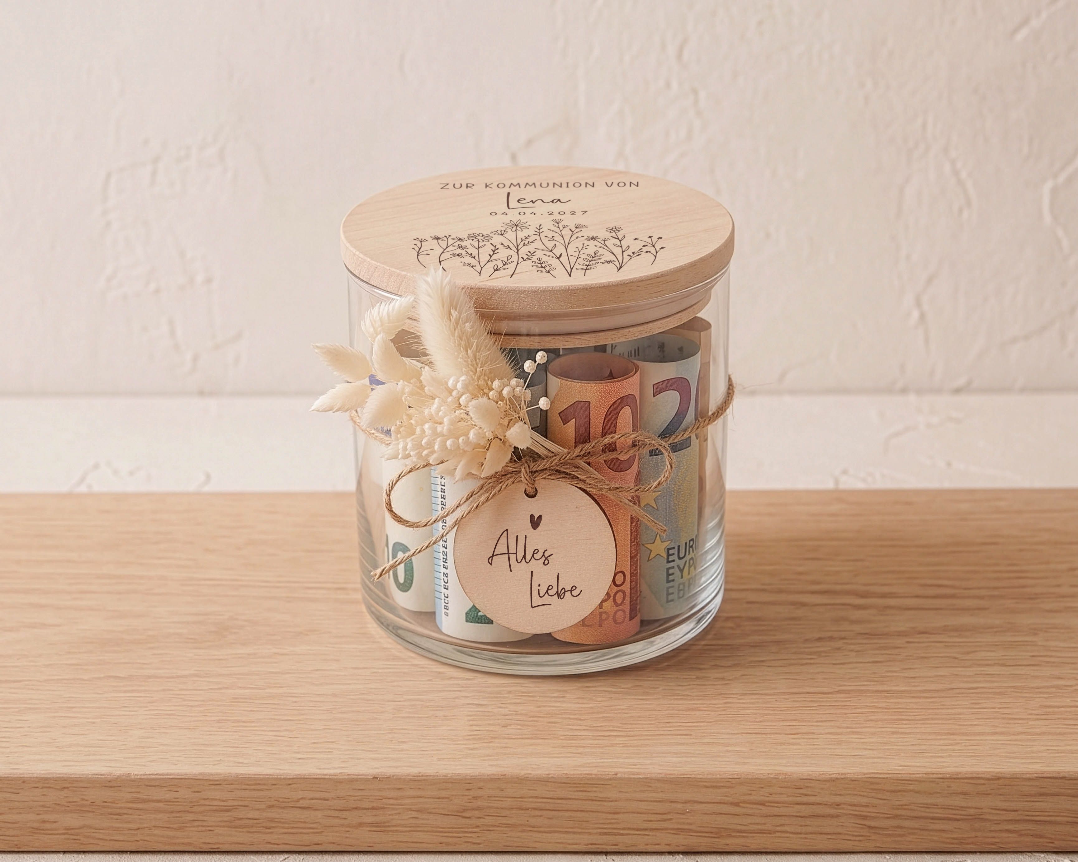 Vorratsglas zur Kommunion mit graviertem Holzdeckel, darauf Blumenwiesen-Motiv. Dazu ein Trockenblumen-Sträußchen und Holzanhänger "Alles Liebe".